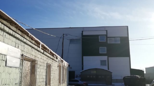 Перед бело-зелёным зданием налево